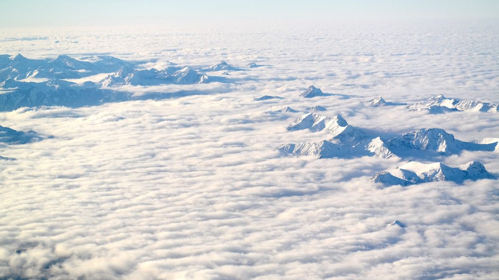 Alperna sedda genom molnen, från flyget