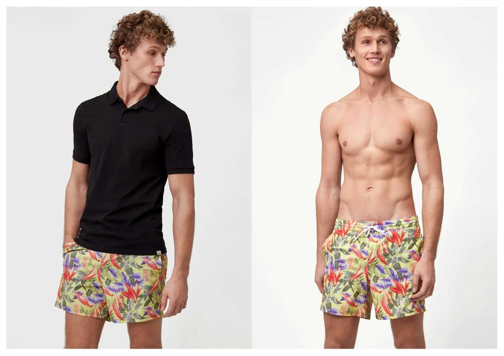 A man wearing a black polo shirt and a floral all-over patterned surf short
