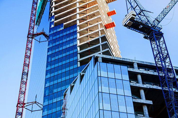 Modern office tower building construction with crane