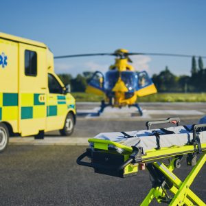 Stretcher against ambulance car and helicopter of emergency medical service. Themes rescue, help and hope.