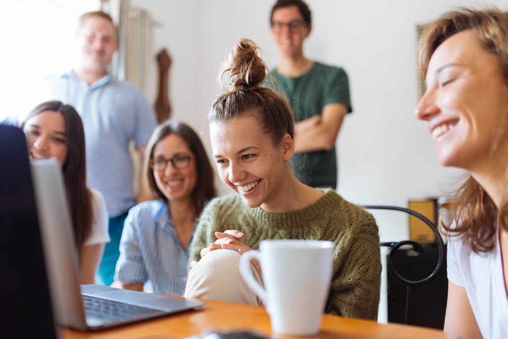 Een groep werknemers volgt samen op een laptop een videocall