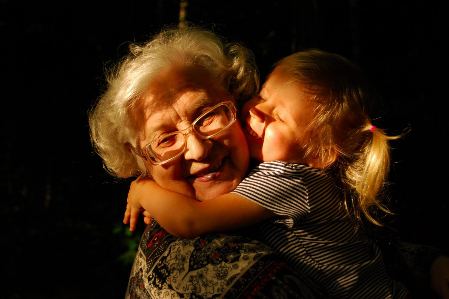 Een oma en kleindochter knuffelen