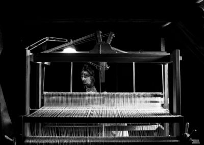 Artist Hanna Norrna sitting at her loom in the attic of Gathenhielmska Huset