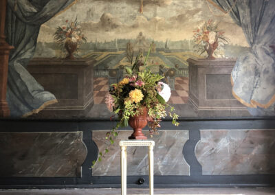 A bouquet of flowers in front of a wall tapestry