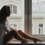 Young woman on windowsill