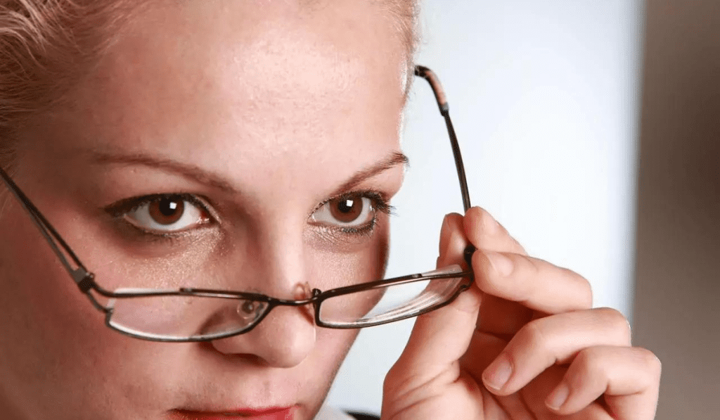Frau macht Augentraining, nimmt Brille ab