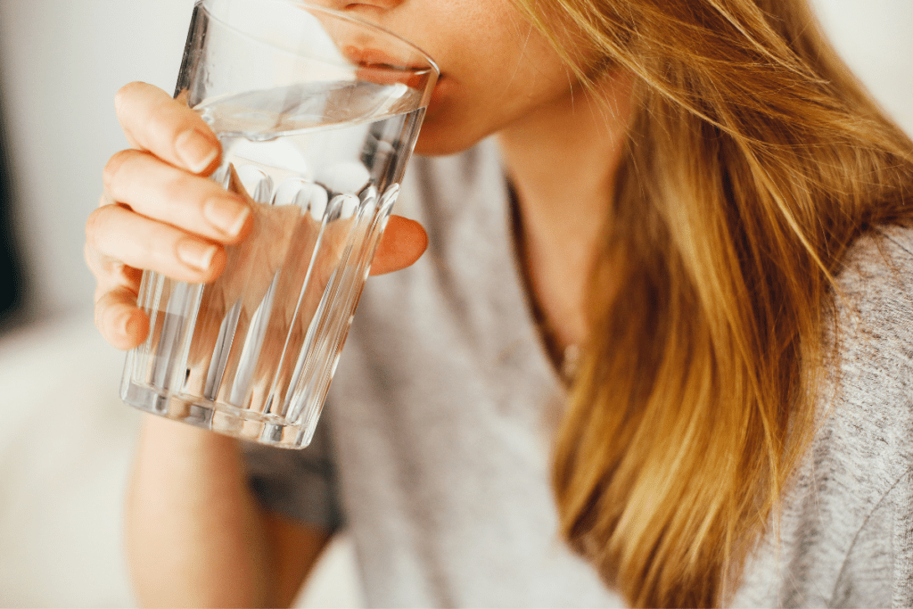 Frau trinkt ein Glas Wasser.