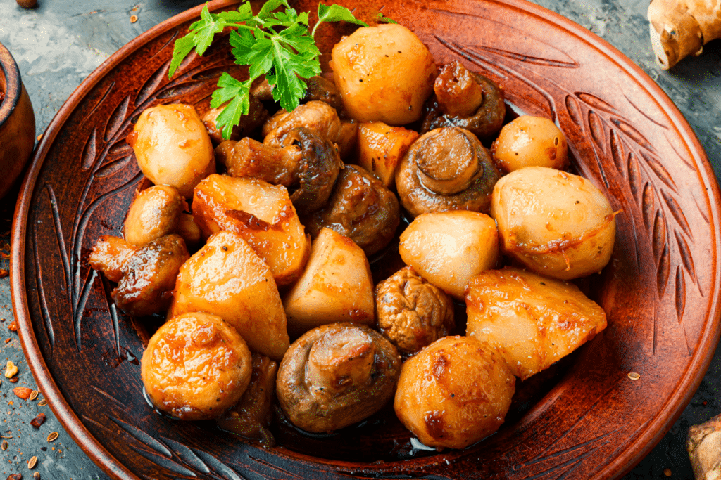 Topinambur Pfanne mit Pilzen und Olivenöl Topinambur im Topf