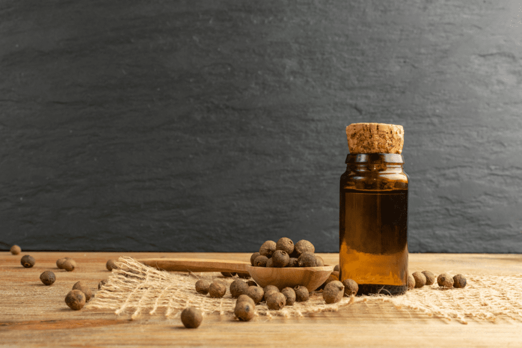 Piment Öl und Allgewürz Beeren auf Holztisch