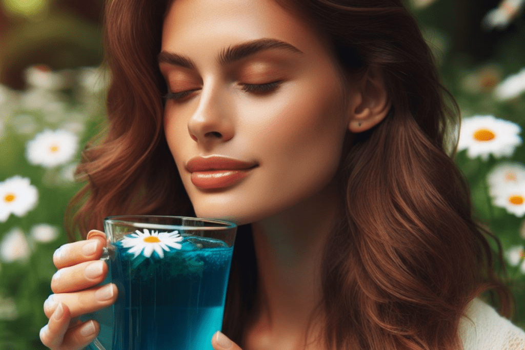 Eine europäische Frau trinkt blauen Tee aus einer Glastasse