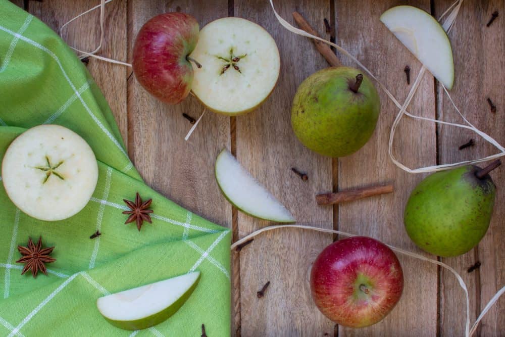 Cut apples and pears on wooden table