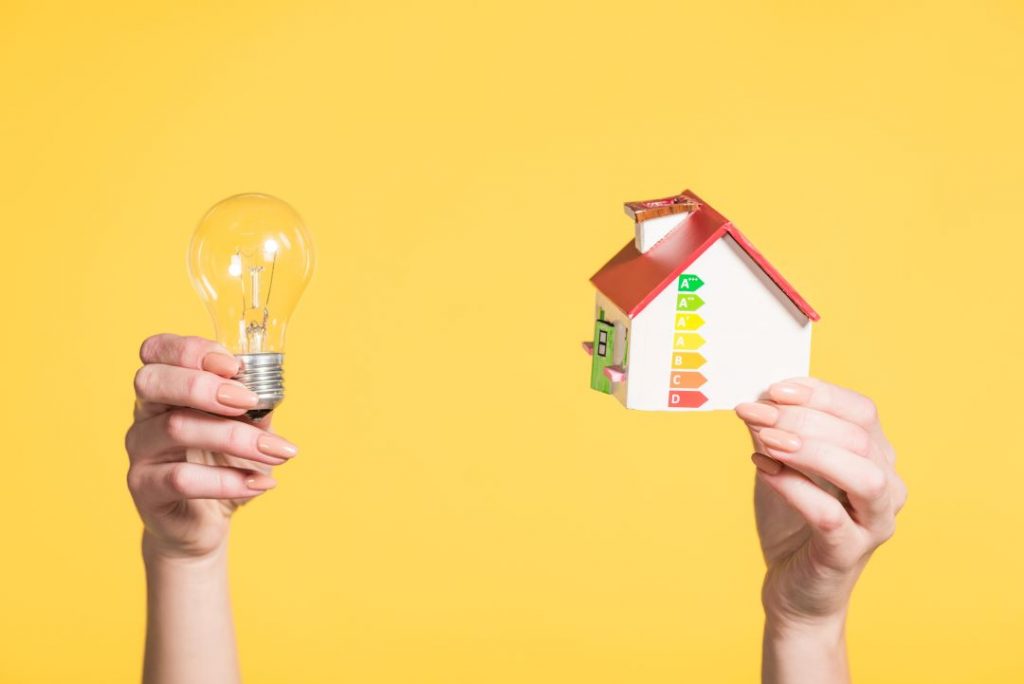 retrofit coordination, a person holding a toy house and a light bulb