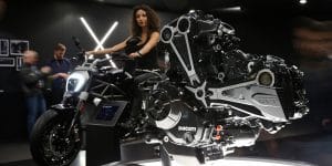 Motere ducati in primo piano e ragazza in sella a una moto in secondo piano, EICMA 2015