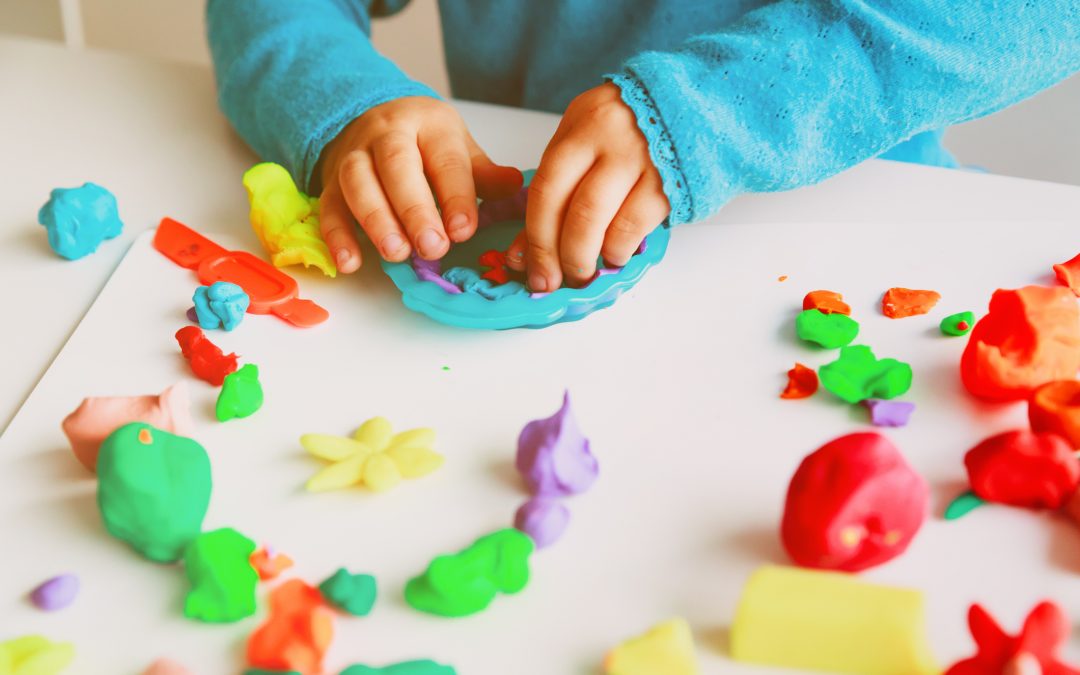 Child playing with clay molding shapes, learning concept