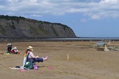 Nogle lokale beboere nyder vejret ved lavvande i Robin Hood Bay - i Yorkshire i Nordengland