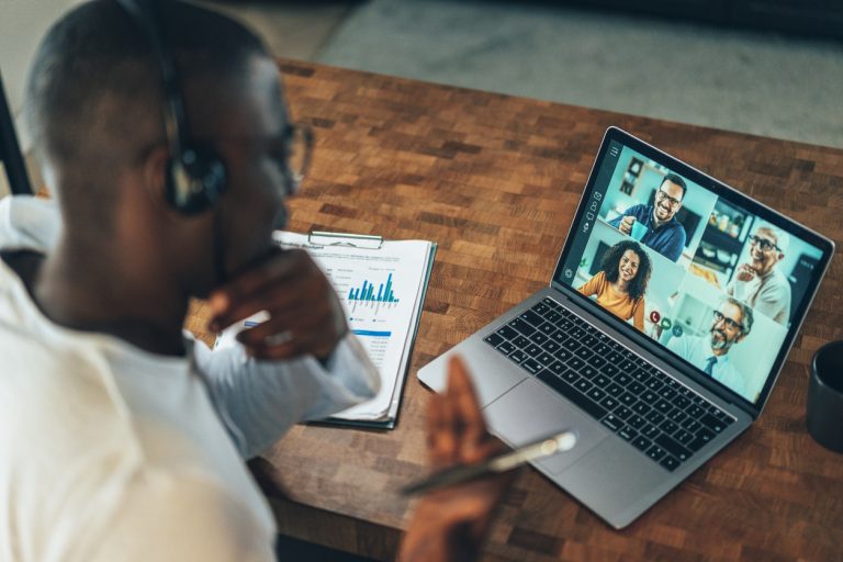 Remote worker on video conference call with diverse distributed team members, demonstrating authentic nearshore partnership communication and cross-border collaboration