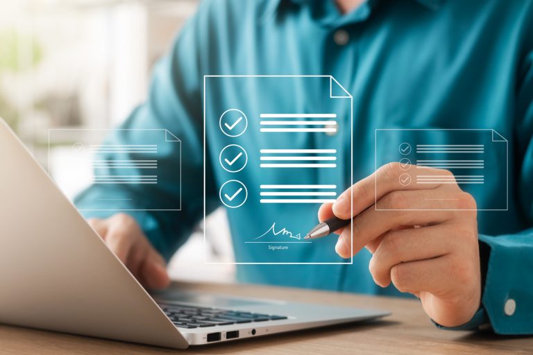 Professional digitally signing compliance documents with checkmarks on transparent interface, representing nearshore partnership legal framework and contract management