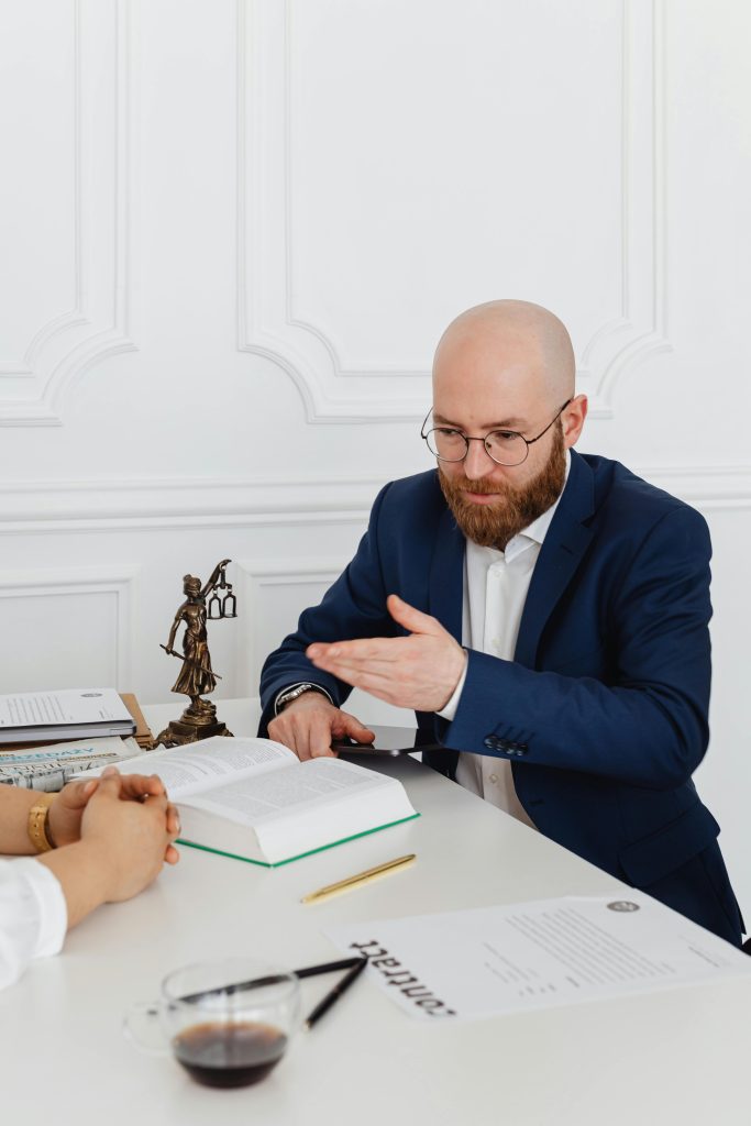 Globen Legal consulting Man in suit consulting with client in elegant office, discussing documents on desk.