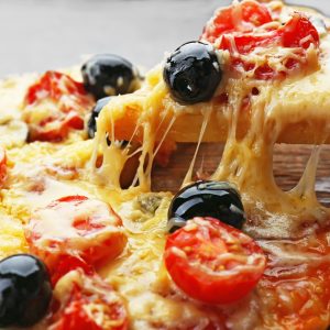 Sliced delicious pizza with olives on wooden plate, close up