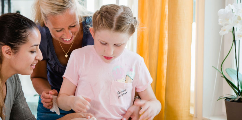 barn leker med deg tillsamman med mamma och personlig assistent