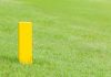 The yellow distance marker pole to inform range of golfing in green golf course. Getty Images/iStockphoto