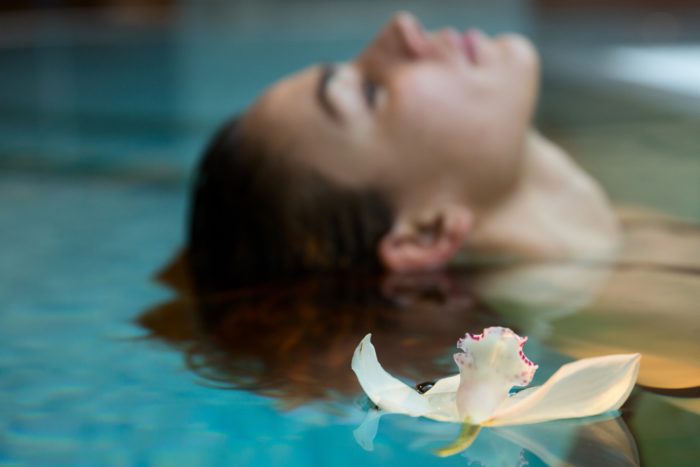 Europe. Italy. Helvetia Thermal SPA Hotel Porretta Terme. model swimming in thermal pool with an orchid floating Universal Images Group via Getty