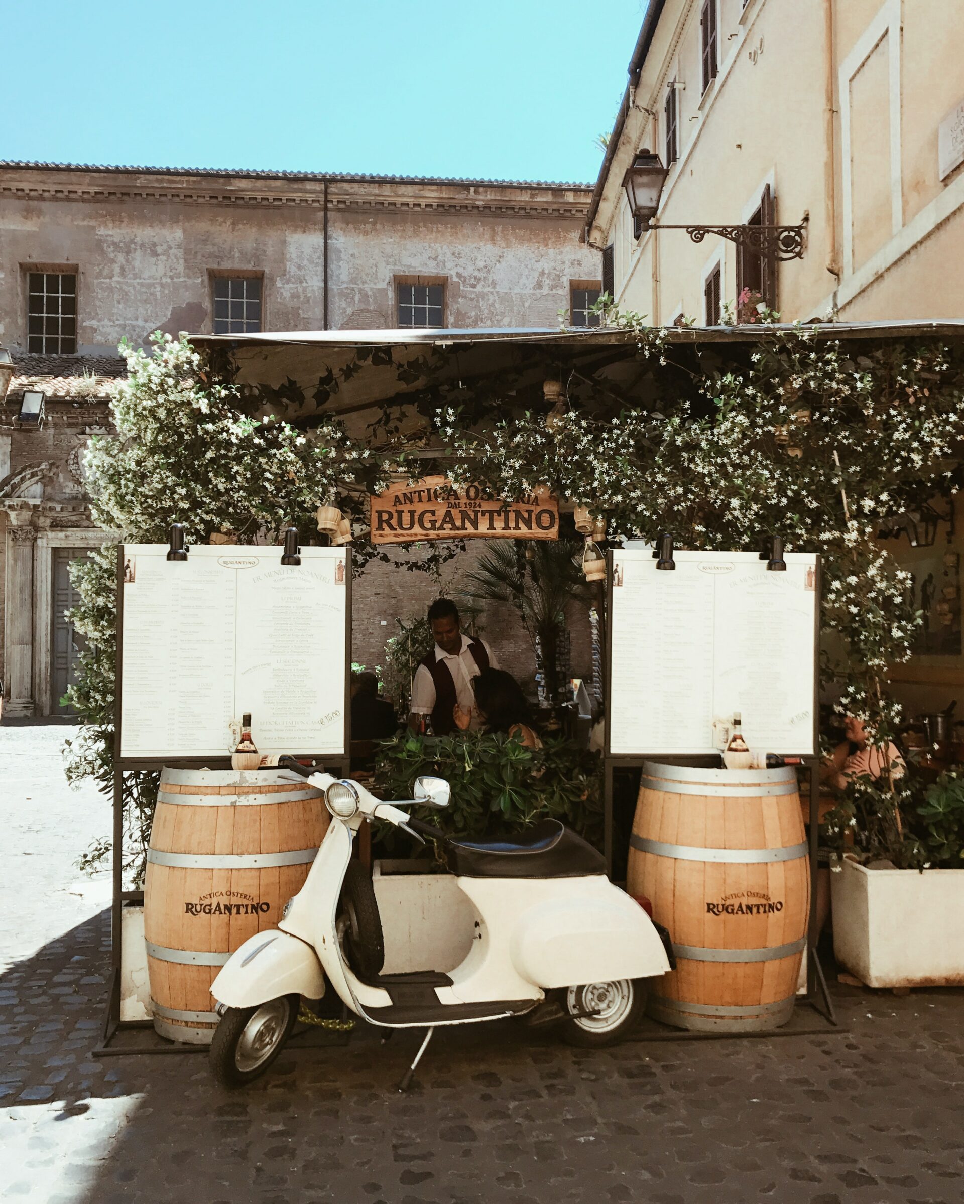 Scooter between two barrels and "Rugantino" board in Italy