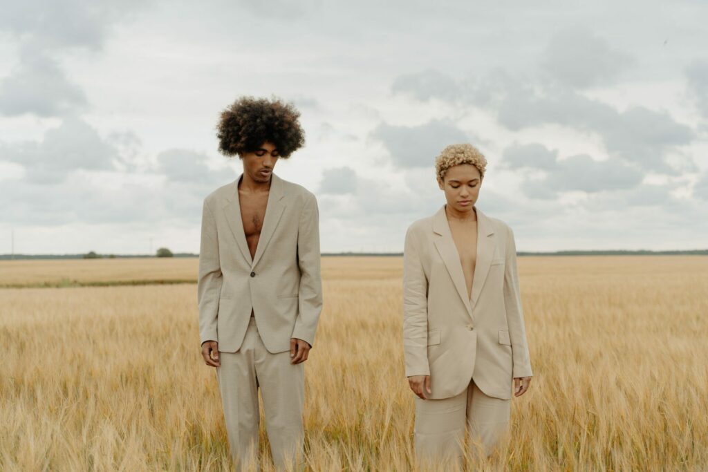 A man and a woman standing in grass