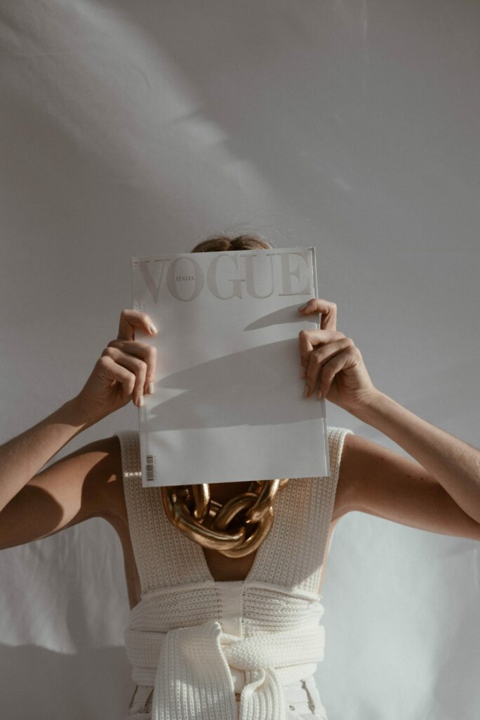 Woman hiding her face with a Vogue magazine