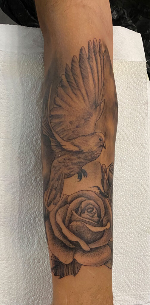 Unterarmtattoo mit Vogel und Rosen