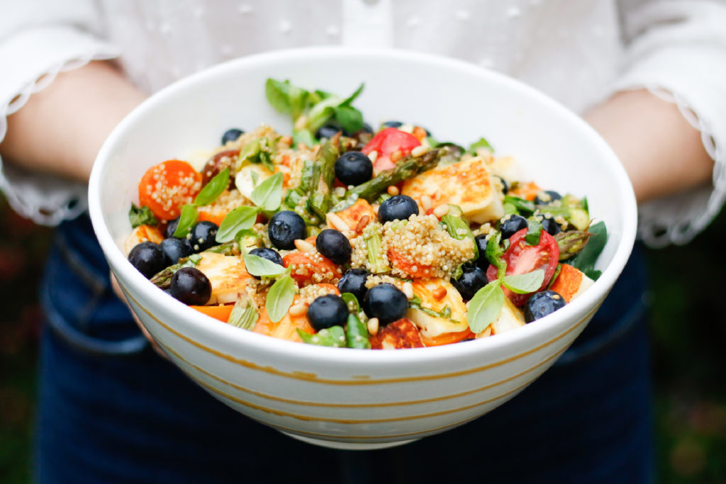 Bunter Quinoa-Salat mit geröstetem Gemüse, Halloumi oder Tofu und Blaubeeren.