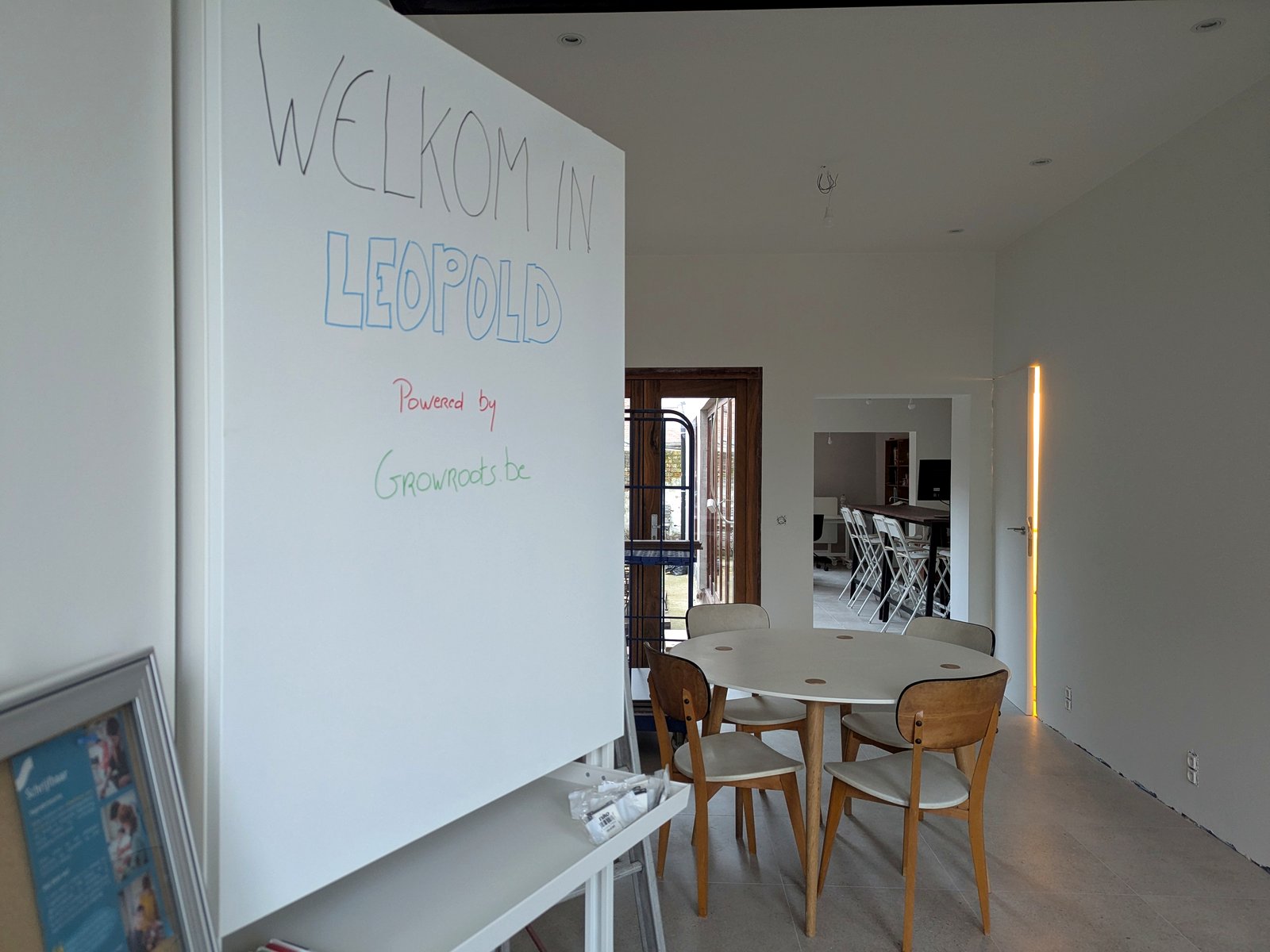 Het gelijkvloers van Leopold in Brugge, met welkomstbord en gedeelde werkruimte