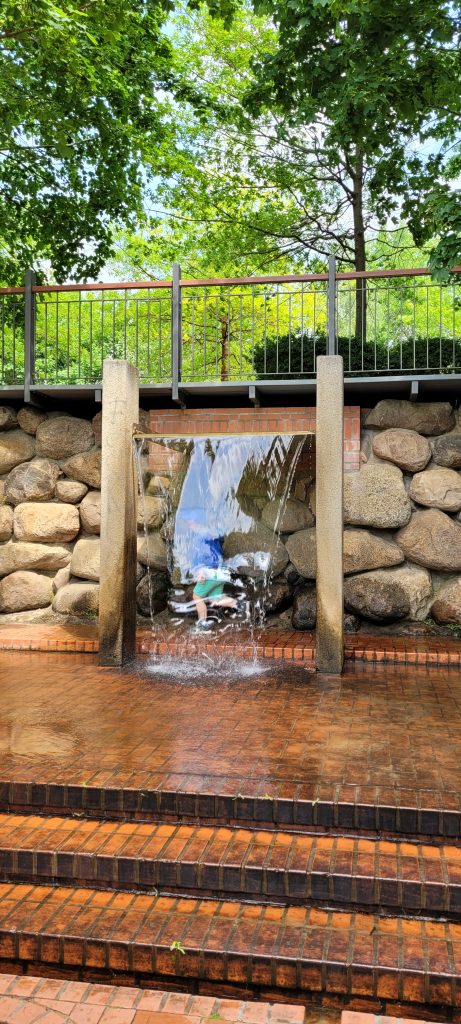 Wasserspielplatz Lübben, Kind läuft hinter bzw. unter kleinem Wasserfall