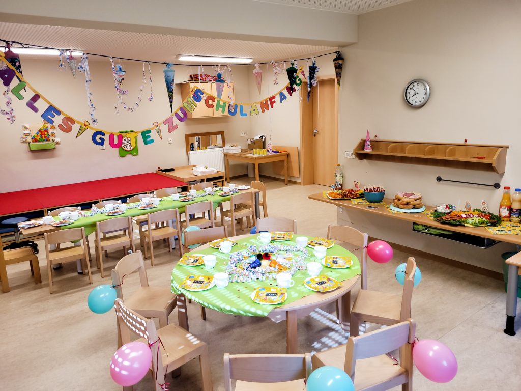 Kitaabschied Frühstück, 2 bunt gedeckte Tische für die Kinder, ein kleines Buffet und hübsch dekorierter Raum mit Luftballons, Luftschlangen, Spruchband