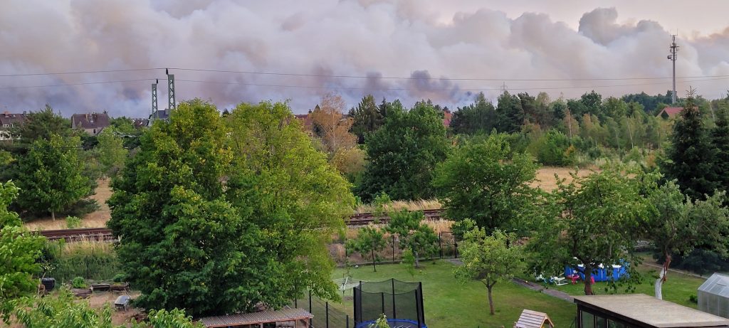 Blick aus Dachfenster auf dicke Rauchwolken am gesamten Horizont vom Feuer