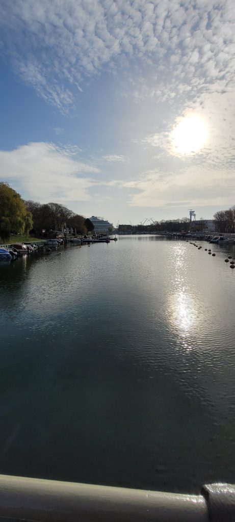 Warnemünde, Blick auf Kanal zur Ostsee mit Sonne am Himmel