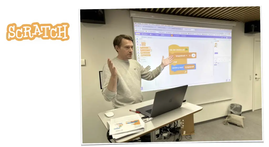 Underviser holder Scratch-kursus med programmering projiceret på væggen