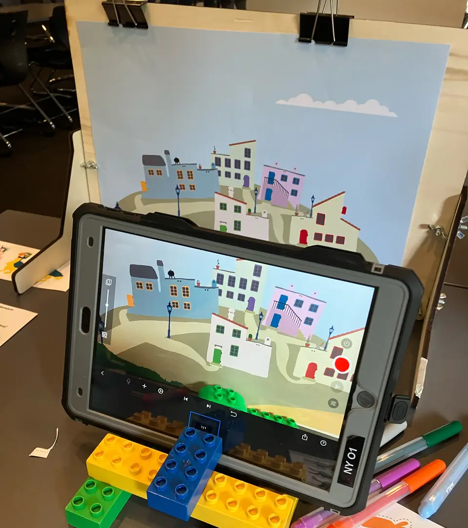 Tablet og baggrund med Kunstnerbyen i et laserskåret stopmotion-studie.