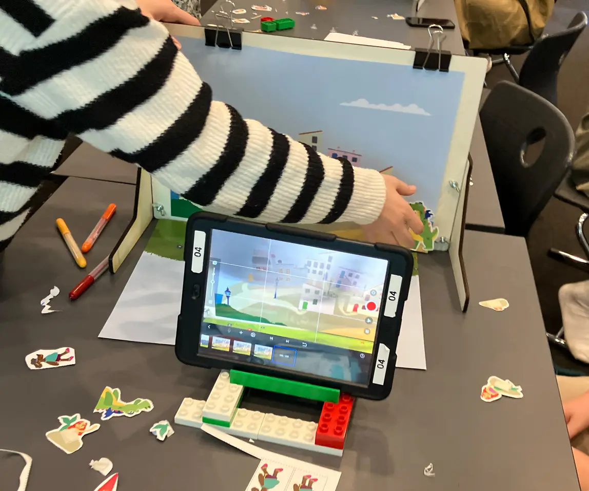 Elev flytter en figur i stopmotion-studiet mens tabletten er klar til optagelse.