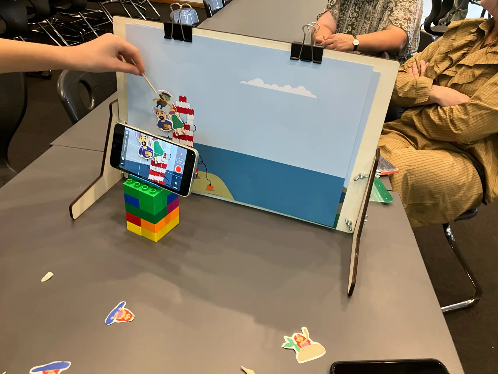 Elever filmer udskårne figurer foran en selvbygget baggrund i stopmotion-studiet.