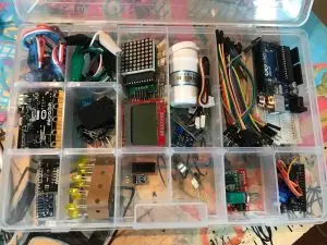 Kasse med micro:bit, Arduino Uno, sensorer, kabler og elektronikkomponenter.
