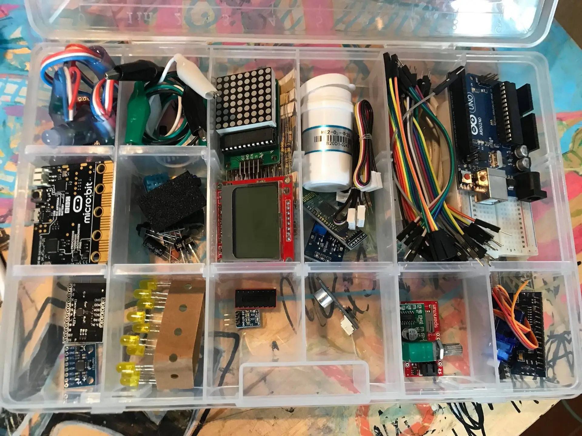 Kasse med micro:bit, Arduino Uno, sensorer, kabler og elektronikkomponenter.