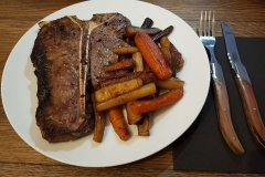T-Bone-Steak mit Beilagen und Besteck