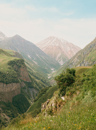 Bilde av fjell med en dal som illustrerer at SEO og tekstproduksjon er en reise.