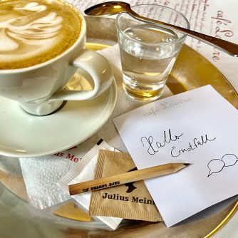 Kaffeetasse mit Cappuccino und ein Zettel auf dem Hallo Ernstfall steht
