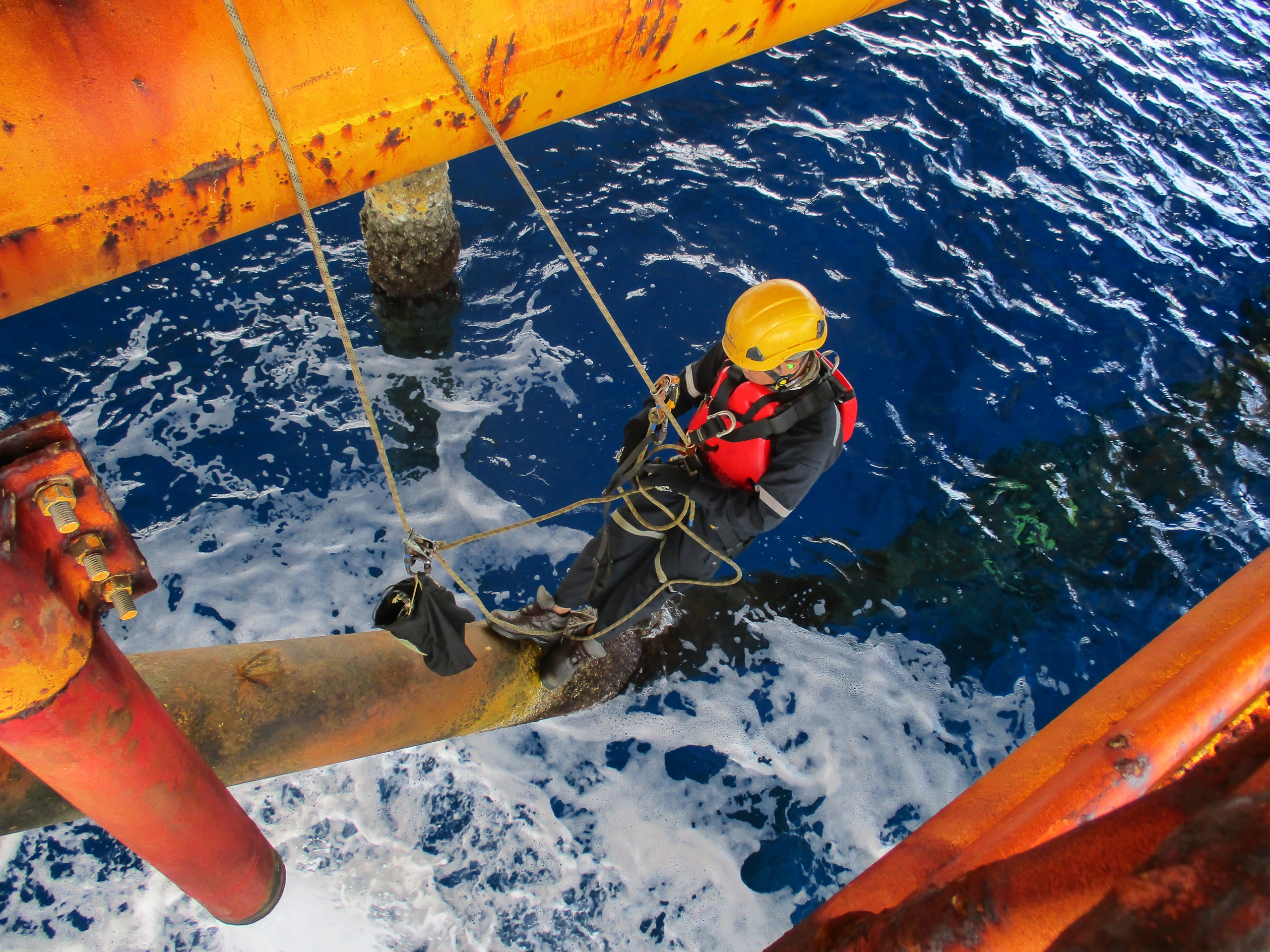 Male worker rope access inspection of thickness offshore drill