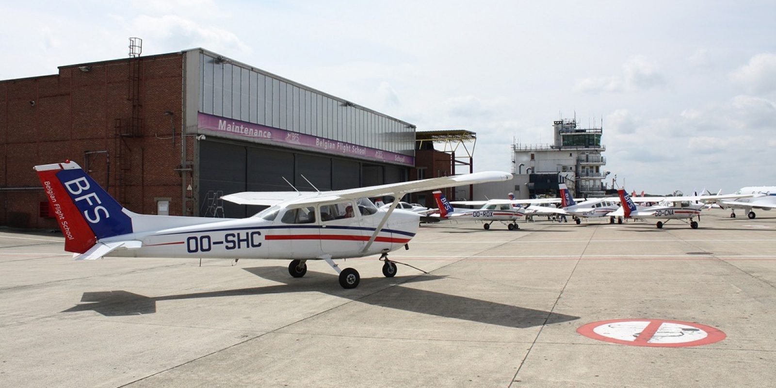 Le OO-SHC est un des Cessna 172 de la flotte BFS, photographié en avant-plan d’une partie de la flotte des « Blue tails ».