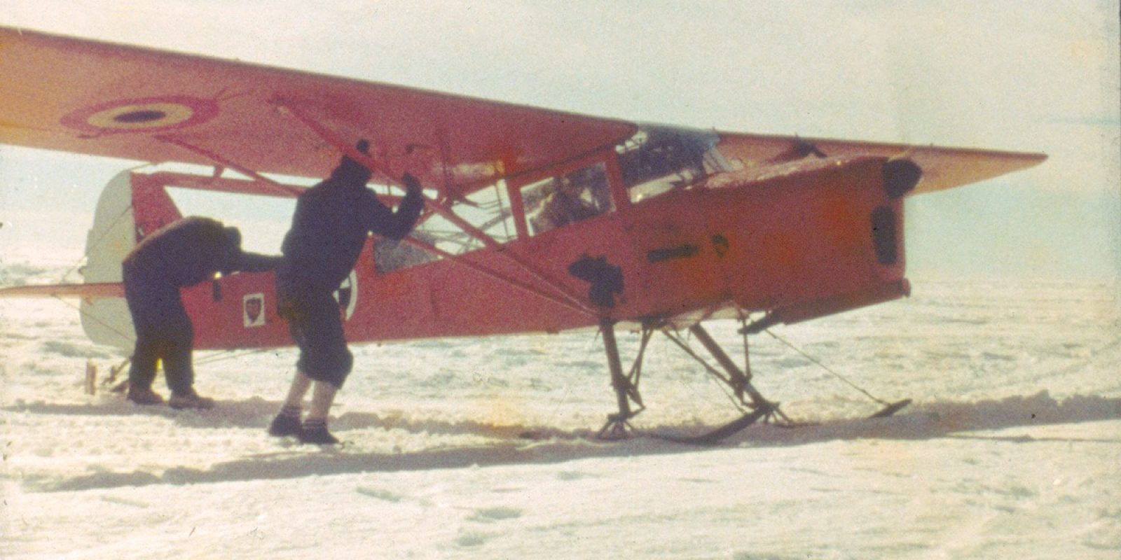 En plein Antarctique lors de la 1ère Année géophysique internationale 1957-1958, l’Auster A-2 effectue un test moteur retenu par des aides car, monté sur skis, cet appareil n’a pas de freins. Cette image est extraite d’un film 16 mm, ce qui explique son léger flou. (Gaston de Gerlache de Goméri via Jean-Claude Heurter)