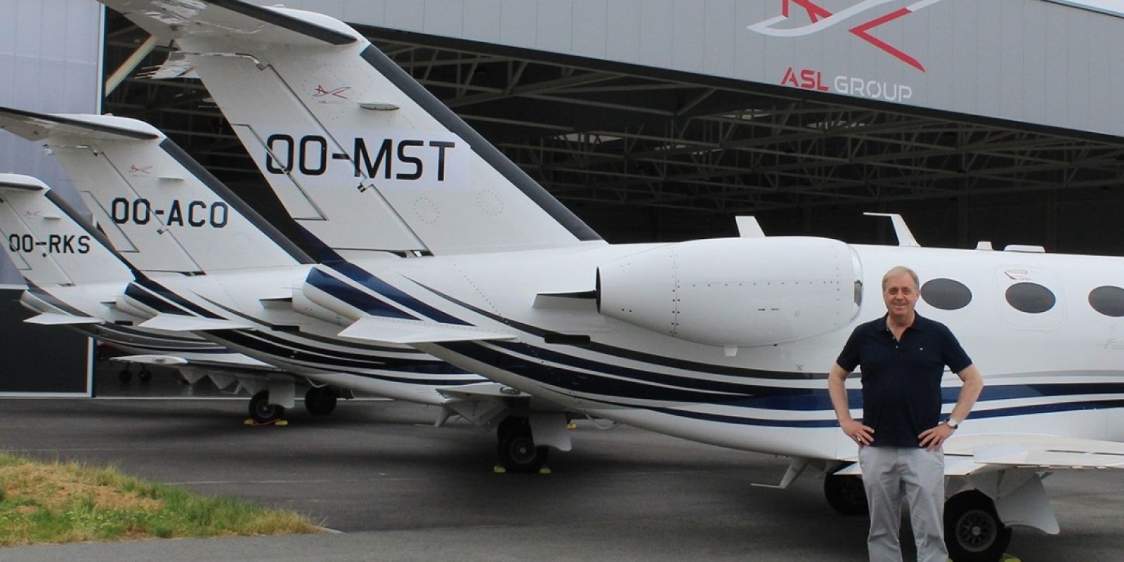 Philippe Bodson, CEO du groupe ASL, et quelques Cessna Citation Mustang alignés devant le deuxième hangar anversois du groupe. (Photo Guy Viselé)