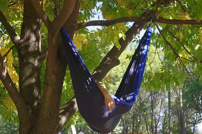 man sleeping in a camping hammock